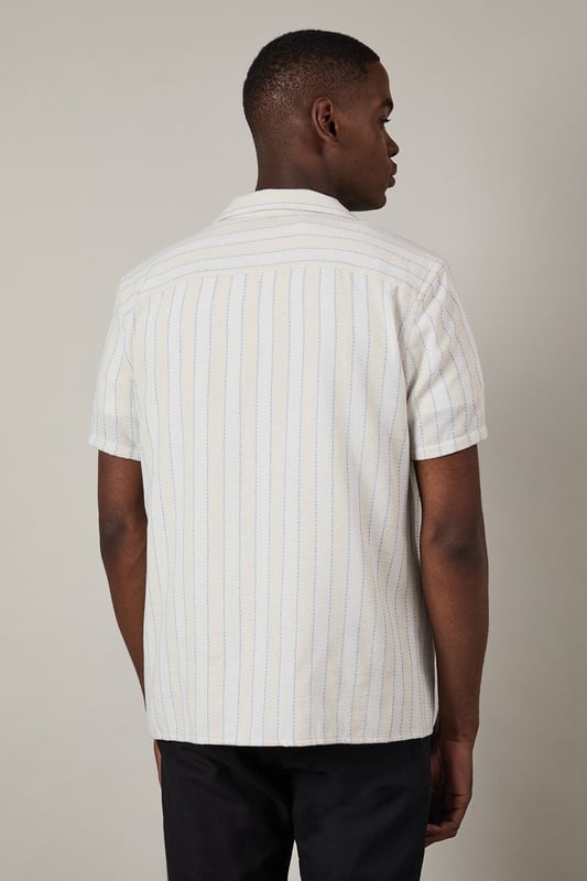 Textured stripe pattern adds subtle dimension to this classic short sleeve shirt
        Revere collar design offers a relaxed, open neckline perfect for warmer days
        Button-through front with clean finishing for effortless style
        Relaxed fit through the body provides comfortable all-day wear
        Versatile woven fabric with textural interest that maintains its shape throughout the day
    
    This Burton textured stripe shirt brings casual sophistication to your everyday wardrobe. The revere collar creates a laid-back yet put-together look that works brilliantly for various occasions. Style it as shown with dark trousers and a simple white t-shirt underneath for an effortless weekend ensemble, perfect for meeting mates at the pub or casual family gatherings. The textured stripe pattern adds character without overwhelming, making this shirt an excellent choice for summer barbecues or watching the match. For a smarter approach, pair with chinos and loafers. The versatile design transitions seamlessly from daytime casual to evening drinks, embodying Burton's commitment to practical yet stylish menswear that fits comfortably into the modern British man's lifestyle.