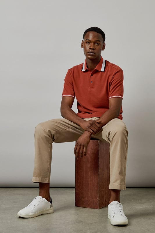 Distinctive jacquard collar with contrasting stripe detail
        Classic button placket with durable buttons for longevity
        Soft cotton fabric for all-day comfort
        Ribbed sleeve cuffs with matching trim for a refined finish
        Regular fit silhouette offering ease of movement
    
    This Burton polo shirt combines timeless style with contemporary detailing, making it a versatile addition to your casual wardrobe. The standout jacquard collar adds character to an otherwise classic design, while the cotton construction ensures breathability and comfort throughout the day. Style it as shown with neutral chinos and white trainers for an effortlessly smart-casual look perfect for weekend pub gatherings or family barbecues. For cooler evenings, layer under a lightweight bomber jacket or casual blazer. The versatile design transitions seamlessly from daytime outings to relaxed evening socials, offering the reliability and understated style that Burton is known for. Machine washable at 30 degrees, this polo maintains its shape and colour with proper care.