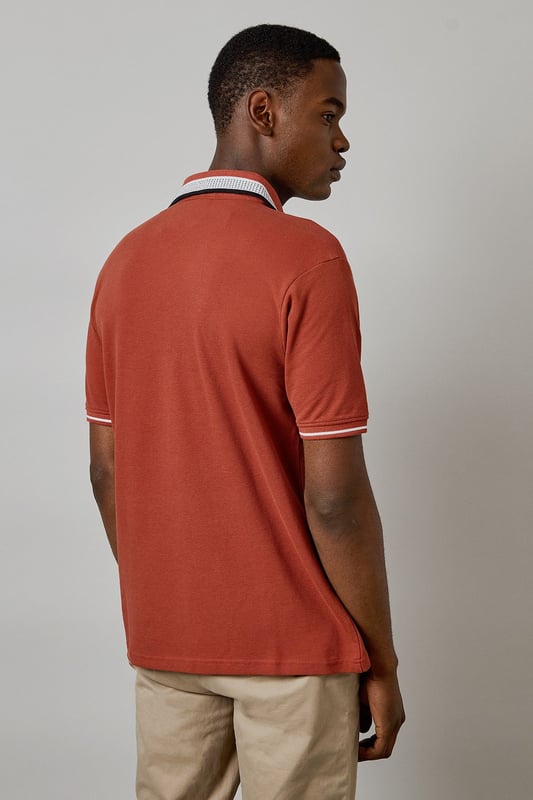 Distinctive jacquard collar with contrasting stripe detail
        Classic button placket with durable buttons for longevity
        Soft cotton fabric for all-day comfort
        Ribbed sleeve cuffs with matching trim for a refined finish
        Regular fit silhouette offering ease of movement
    
    This Burton polo shirt combines timeless style with contemporary detailing, making it a versatile addition to your casual wardrobe. The standout jacquard collar adds character to an otherwise classic design, while the cotton construction ensures breathability and comfort throughout the day. Style it as shown with neutral chinos and white trainers for an effortlessly smart-casual look perfect for weekend pub gatherings or family barbecues. For cooler evenings, layer under a lightweight bomber jacket or casual blazer. The versatile design transitions seamlessly from daytime outings to relaxed evening socials, offering the reliability and understated style that Burton is known for. Machine washable at 30 degrees, this polo maintains its shape and colour with proper care.