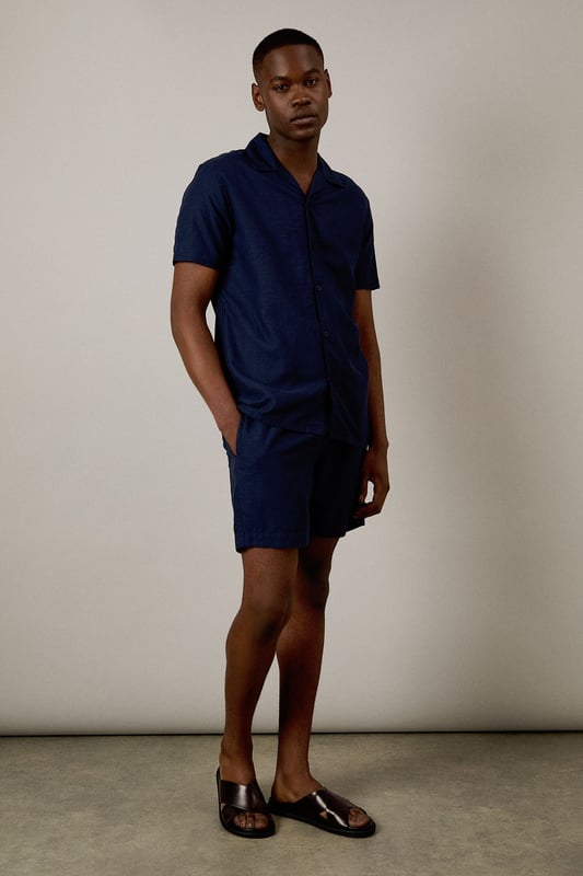 Linen blend fabric offers breathable comfort for warm-weather wear
        Relaxed fit with elasticated waistband for all-day ease
        Side pockets provide practical storage for essentials
        Mid-thigh length creates a flattering silhouette
        Versatile design that pairs effortlessly with both casual and smart-casual attire
    
    These Burton shorts combine comfort and style for the modern man who values both practicality and appearance. The linen blend construction ensures breathability during warmer months whilst maintaining a structured look that works across multiple settings. Style them as shown with a crisp white t-shirt and matching short-sleeved shirt for a coordinated summer ensemble perfect for weekend barbecues or casual pub gatherings with mates. For a more relaxed approach, pair with your favourite graphic tee and trainers for an effortless daytime look. The neutral tone makes these shorts incredibly versatile, allowing them to complement your existing wardrobe with ease. Ideal for family gatherings, sporting events or casual outings, these shorts will quickly become your go-to choice for comfortable yet presentable summer dressing.