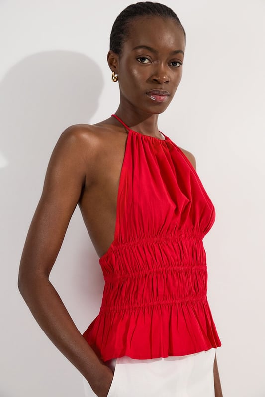 Shirred Cotton Tiered Halter Neck Woven Top This Karen Millen woven top combines casual charm with refined detailing, making it a versatile addition to your summer wardrobe. The shirred cotton construction offers both structure and comfort, while the halterneck design creates a feminine neckline that frames the decolletage beautifully. Style with crisp white trousers as shown for a fresh daytime look, or pair with tailored shorts and sandals for weekend brunches. The boxy fit works wonderfully with slim-fitting bottoms to create a balanced silhouette. Add a woven bag and delicate jewellery for family gatherings or casual outings. This piece transitions effortlessly from day to evening; simply swap your flats for block heels and add statement earrings for alfresco dining. Machine washable and easy to care for, this top delivers on both style and practicality. Crafted from pure cotton for breathable comfort throughout the day Distinctive halterneck design with tie fastening at the back for an adjustable fit Intricate shirring detail across the waist creates a flattering silhouette Tiered hem adds movement and dimension to this boxy-fit top Sleeveless style perfect for warmer weather with elegant shoulder-baring appeal