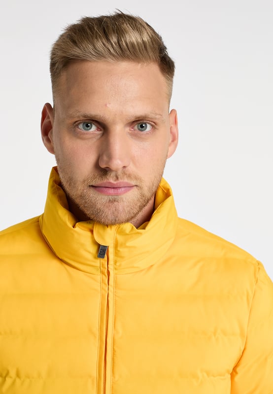 Mo Gewatteerd winterjack Heren geel Deze gewatteerde gewatteerde jas van Mo voelt zeer zacht aan en aangenaam licht. Het tijdloze model heeft een rechte snit, is wind- en waterdicht en is perfect geïsoleerd met het hoogwaardige synthetische vulmateriaal. De afzonderlijke kamers zijn zonder naden gemaakt, zodat er geen vocht door kan dringen. De ritssluiting over de volledige lengte loopt door in een opstaande kraag die voor extra warmte zorgt. Twee zijzakken met ritssluiting en een binnenzak maken de doordachte winteroutfit compleet.