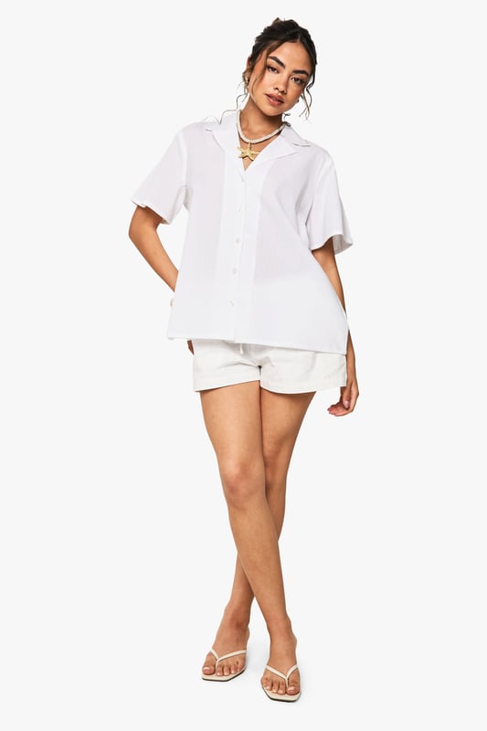 Boxy fit short-sleeved shirt with resort-inspired print for a relaxed holiday aesthetic
        Classic collar design with full button-through front for versatile styling options
        Linen-look fabric offers a lightweight, breathable feel perfect for warmer weather
        Oversized silhouette provides effortless comfort whilst maintaining a fashion-forward appearance
        Straight hemline that can be worn tucked in or out depending on your desired look
    
    This oversized resort print shirt embodies casual chic with its boxy silhouette and linen-look texture. Style it as seen with coordinating shorts for a matching set that's perfect for beach days or city brunches. For cooler evenings, layer over a simple vest top and pair with wide-leg trousers and trainers for an effortlessly cool ensemble. The versatile design works brilliantly with denim shorts and sandals for daytime adventures, or tucked into a midi skirt with layered jewellery for casual gatherings. The relaxed fit makes it ideal for family barbecues and informal garden parties, whilst the button-through design allows for styling flexibility-wear fully buttoned, partially open, or as a light layer over a cami top. This Boohoo staple transitions seamlessly from holiday packing essential to weekend wardrobe favourite.