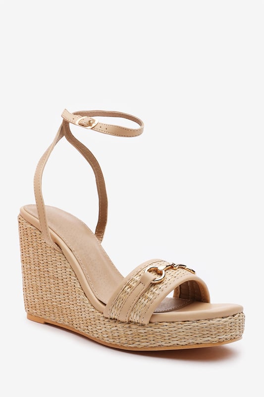 Wheres That From Womens 'Jenny' Wedge Heeled Sandals With Buckle Ankle Straps Elevate your warm-weather wardrobe with these Jenny Wedge Heeled Sandals With Buckle Ankle Straps. Designed with a raffia-style flatform heel and sleek ankle strap, they offer both stability and feminine flair. The gold-toned horse-bit detail adds a polished finish, making them perfect for garden parties, summer weddings, or casual chic days. Lightweight and stylish for all-day comfort. Key Features: • Material: Faux leather upper with woven raffia wedge base • Design: Open-toe wedge with gold detail and ankle strap • Closure: Adjustable ankle buckle for a secure fit