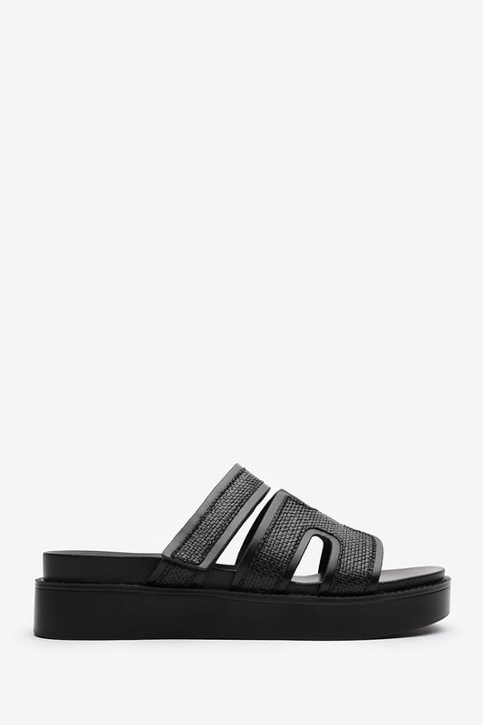 Wheres That From Womens 'Splendor' Slider Flatform Sandals With Cutout Straps Add a touch of glamour to your casual looks with these Splendor Slider Flatform Sandals With Cutout Straps. Featuring textured woven panels and metallic black trims, they combine comfort and sophistication in one easy slide-on style. The cushioned footbed and elevated sole provide support with a fashionable edge. Perfect for day-to-night wear, holidays, or city strolls. Key Features: • Material: Woven textile and faux leather upper with padded insole • Design: Wide-cut slide with cut-out detailing and black metallic trim • Closure: Slip-on style for ease and comfort