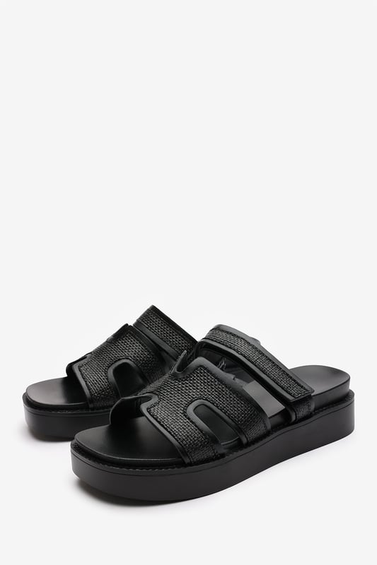 Wheres That From Womens 'Splendor' Slider Flatform Sandals With Cutout Straps Add a touch of glamour to your casual looks with these Splendor Slider Flatform Sandals With Cutout Straps. Featuring textured woven panels and metallic black trims, they combine comfort and sophistication in one easy slide-on style. The cushioned footbed and elevated sole provide support with a fashionable edge. Perfect for day-to-night wear, holidays, or city strolls. Key Features: • Material: Woven textile and faux leather upper with padded insole • Design: Wide-cut slide with cut-out detailing and black metallic trim • Closure: Slip-on style for ease and comfort