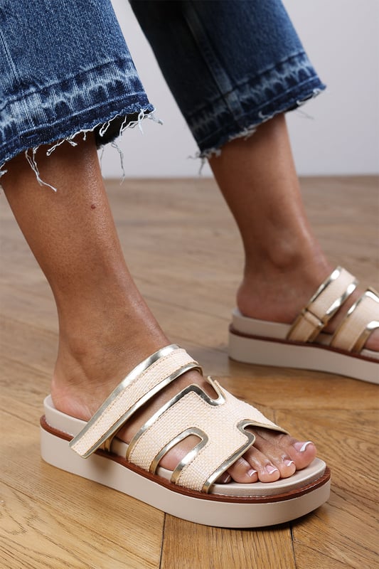 Wheres That From Womens 'Splendor' Slider Flatform Sandals With Cutout Straps Add a touch of glamour to your casual looks with these Splendor Slider Flatform Sandals With Cutout Straps. Featuring textured woven panels and metallic gold trims, they combine comfort and sophistication in one easy slide-on style. The cushioned footbed and elevated sole provide support with a fashionable edge. Perfect for day-to-night wear, holidays, or city strolls. Key Features: • Material: Woven textile and faux leather upper with padded insole • Design: Wide-cut slide with cut-out detailing and gold metallic trim • Closure: Slip-on style for ease and comfort