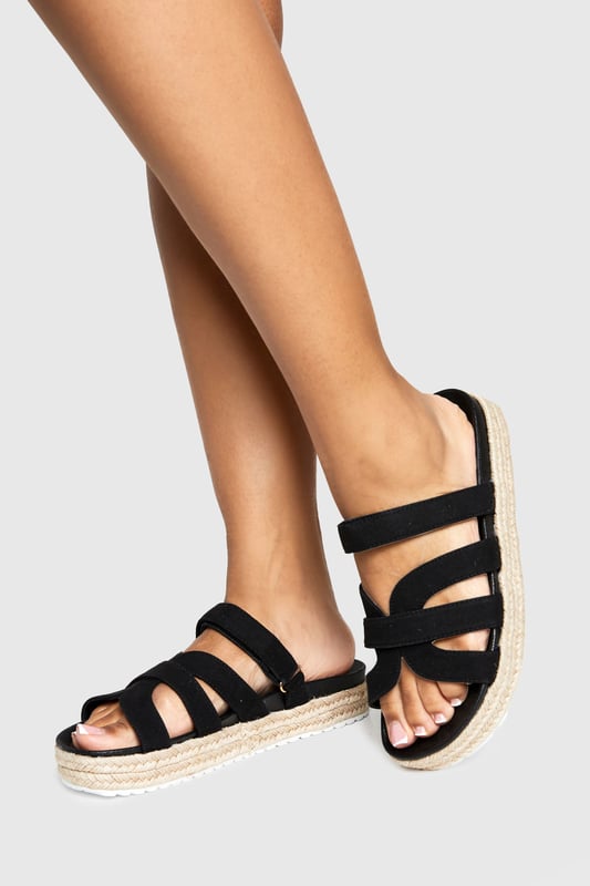 Wide Fit Faux Suede Cross Strap Flatform Sandals Wide fit design for all-day comfort and easy wear
Stylish cross-strap detailing adds visual interest to the upper
Flat platform with espadrille-style rope detailing around the sole
Slip-on style for effortless wearing
Heel height between 0-2cm, perfect for extended wear
These platform sandals combine contemporary style with practical comfort, making them an essential addition to your summer wardrobe. The cross-strap design creates a fashionable silhouette whilst the wide fit ensures they remain comfortable throughout the day. The espadrille-inspired platform sole adds a touch of Mediterranean flair to your look without sacrificing stability. Style these versatile sandals with flowing maxi dresses and oversized sunglasses for casual daytime outings, or pair with cropped linen trousers and a fitted tee for family gatherings. They transition seamlessly from beach days to city strolls, offering the perfect blend of fashion and function. The neutral design makes them incredibly adaptable, working beautifully with both bold patterns and understated ensembles for a range of casual occasions throughout the warmer months.