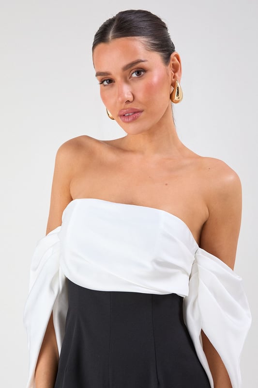 Striking bardot neckline with dramatic volume sleeves for a bold silhouette
        Elegant bandeau bodice with structured design for a flattering fit
        Flowing wide-leg trousers create a sophisticated and elongating effect
        Sleek back design showcases shoulders for a touch of allure
        Versatile jumpsuit perfect for formal occasions and evening events
    
    Make a statement entrance in this show-stopping bardot jumpsuit from Misspap. The dramatic volume sleeves create an architectural silhouette that commands attention, whilst the clean lines of the wide-leg cut offer effortless movement as you glide across the room. Style with strappy heels and statement earrings as seen on our model for maximum impact at summer weddings or cocktail parties. For cooler evenings, drape a tailored blazer over your shoulders without compromising the jumpsuit's striking sleeve detail. The bandeau neckline beautifully frames your dcolletage, making this piece ideal for showcasing a special necklace or simply letting the garment's elegant design speak for itself. A true occasion piece that balances contemporary drama with timeless sophistication.