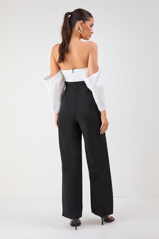 Striking bardot neckline with dramatic volume sleeves for a bold silhouette
        Elegant bandeau bodice with structured design for a flattering fit
        Flowing wide-leg trousers create a sophisticated and elongating effect
        Sleek back design showcases shoulders for a touch of allure
        Versatile jumpsuit perfect for formal occasions and evening events
    
    Make a statement entrance in this show-stopping bardot jumpsuit from Misspap. The dramatic volume sleeves create an architectural silhouette that commands attention, whilst the clean lines of the wide-leg cut offer effortless movement as you glide across the room. Style with strappy heels and statement earrings as seen on our model for maximum impact at summer weddings or cocktail parties. For cooler evenings, drape a tailored blazer over your shoulders without compromising the jumpsuit's striking sleeve detail. The bandeau neckline beautifully frames your dcolletage, making this piece ideal for showcasing a special necklace or simply letting the garment's elegant design speak for itself. A true occasion piece that balances contemporary drama with timeless sophistication.