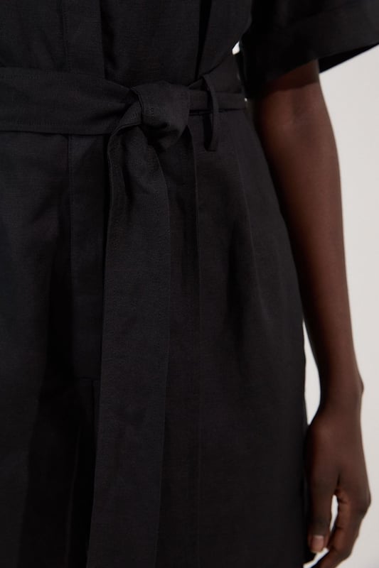 This Karen Millen playsuit combines effortless style with practical design for versatile daywear. The woven viscose linen fabric offers a natural texture and comfortable feel, perfect for warmer days. The belted waist creates a feminine shape while the collared neckline maintains a smart edge. Layer with a lightweight cardigan when the temperature drops, or add a crossbody bag for hands-free convenience during city explorations. This playsuit transitions seamlessly from shopping trips to alfresco dining, making it an essential addition to your warm-weather wardrobe.  Crafted from a viscose linen blend Classic collared neckline with button-through front design Short sleeves with neat cuffs Practical chest pockets Matching fabric belt