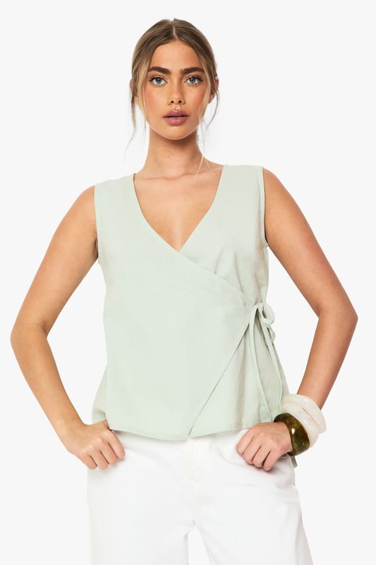 Linen Wrap Front Top Elegant wrap design with side tie detail for adjustable fit
Sleeveless silhouette perfect for warmer weather
V-neckline creates a flattering frame for the dcolletage
Cotton-linen blend fabric offers breathable comfort
Versatile regular fit suitable for various body types
This effortlessly chic wrap top combines casual comfort with sophisticated style. The lightweight cotton-linen blend creates a breezy feel that's ideal for summer days whilst maintaining structure for a polished look. Style with white wide-leg trousers as shown for a fresh daytime ensemble, or pair with tailored shorts and sandals for casual gatherings. The adjustable side tie allows you to customise the fit to your preference, making it wonderfully versatile. For family brunches, team with denim and trainers, adding a woven bag for texture. This Boohoo staple transitions seamlessly from day to evening - simply swap your casual accessories for statement jewellery and you're ready for sunset drinks with friends.