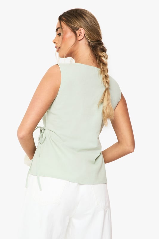 Linen Wrap Front Top Elegant wrap design with side tie detail for adjustable fit
Sleeveless silhouette perfect for warmer weather
V-neckline creates a flattering frame for the dcolletage
Cotton-linen blend fabric offers breathable comfort
Versatile regular fit suitable for various body types
This effortlessly chic wrap top combines casual comfort with sophisticated style. The lightweight cotton-linen blend creates a breezy feel that's ideal for summer days whilst maintaining structure for a polished look. Style with white wide-leg trousers as shown for a fresh daytime ensemble, or pair with tailored shorts and sandals for casual gatherings. The adjustable side tie allows you to customise the fit to your preference, making it wonderfully versatile. For family brunches, team with denim and trainers, adding a woven bag for texture. This Boohoo staple transitions seamlessly from day to evening - simply swap your casual accessories for statement jewellery and you're ready for sunset drinks with friends.