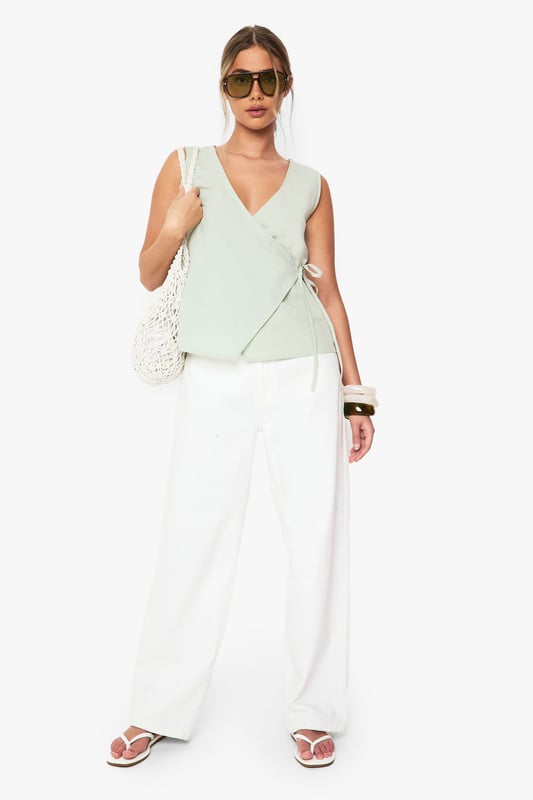 Linen Wrap Front Top Elegant wrap design with side tie detail for adjustable fit
Sleeveless silhouette perfect for warmer weather
V-neckline creates a flattering frame for the dcolletage
Cotton-linen blend fabric offers breathable comfort
Versatile regular fit suitable for various body types
This effortlessly chic wrap top combines casual comfort with sophisticated style. The lightweight cotton-linen blend creates a breezy feel that's ideal for summer days whilst maintaining structure for a polished look. Style with white wide-leg trousers as shown for a fresh daytime ensemble, or pair with tailored shorts and sandals for casual gatherings. The adjustable side tie allows you to customise the fit to your preference, making it wonderfully versatile. For family brunches, team with denim and trainers, adding a woven bag for texture. This Boohoo staple transitions seamlessly from day to evening - simply swap your casual accessories for statement jewellery and you're ready for sunset drinks with friends.