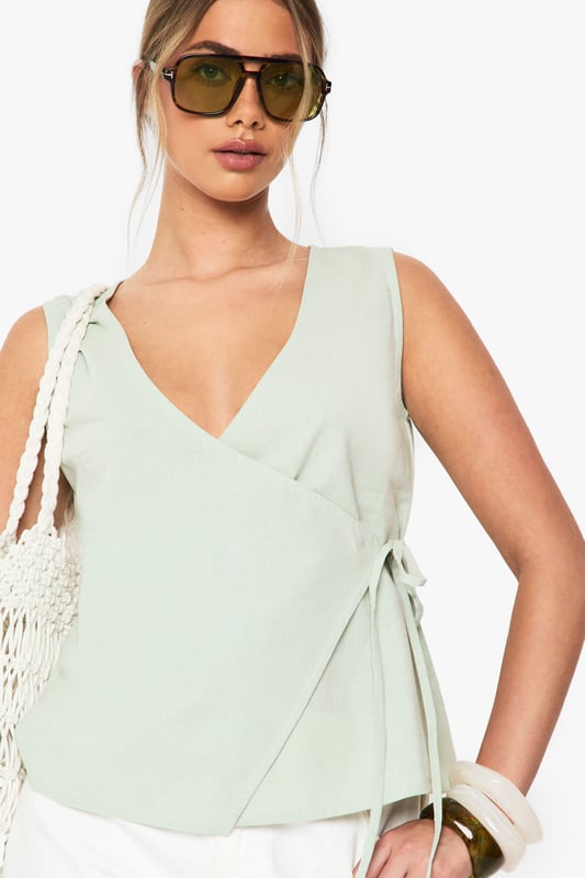 Linen Wrap Front Top Elegant wrap design with side tie detail for adjustable fit
Sleeveless silhouette perfect for warmer weather
V-neckline creates a flattering frame for the dcolletage
Cotton-linen blend fabric offers breathable comfort
Versatile regular fit suitable for various body types
This effortlessly chic wrap top combines casual comfort with sophisticated style. The lightweight cotton-linen blend creates a breezy feel that's ideal for summer days whilst maintaining structure for a polished look. Style with white wide-leg trousers as shown for a fresh daytime ensemble, or pair with tailored shorts and sandals for casual gatherings. The adjustable side tie allows you to customise the fit to your preference, making it wonderfully versatile. For family brunches, team with denim and trainers, adding a woven bag for texture. This Boohoo staple transitions seamlessly from day to evening - simply swap your casual accessories for statement jewellery and you're ready for sunset drinks with friends.