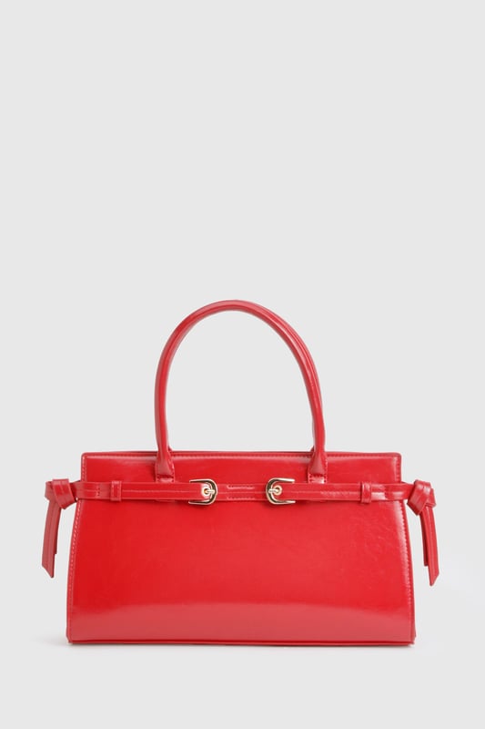 Structured design with elegant buckle detail and gold-tone hardware
        Sleek top handle for sophisticated hand-carry option
        High-shine finish for a statement look
        Spacious interior with zip pocket for secure storage
        Adjustable side buckles for customisable shape
    
    This structured handbag combines practicality with urban chic, perfect for elevating your night-out ensemble. The distinctive buckle detail and glossy finish create a bold statement piece that commands attention, whilst the compact yet roomy interior offers ample space for your evening essentials. Style with contrasting casual pieces like distressed denim and a graphic top for an effortlessly cool look, or pair with a sleek bodycon dress and strappy heels for a more polished club appearance. The versatile size makes it ideal for drinks with friends or dancing the night away, whilst the secure fastening ensures your belongings stay safe throughout your adventures. A true Boohoo staple that transitions seamlessly from early evening cocktails to late-night revelry.