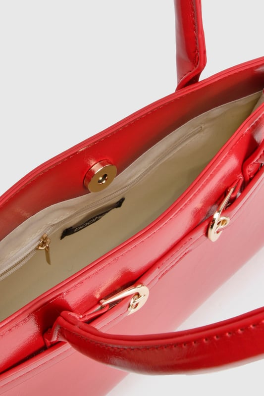 Structured design with elegant buckle detail and gold-tone hardware
        Sleek top handle for sophisticated hand-carry option
        High-shine finish for a statement look
        Spacious interior with zip pocket for secure storage
        Adjustable side buckles for customisable shape
    
    This structured handbag combines practicality with urban chic, perfect for elevating your night-out ensemble. The distinctive buckle detail and glossy finish create a bold statement piece that commands attention, whilst the compact yet roomy interior offers ample space for your evening essentials. Style with contrasting casual pieces like distressed denim and a graphic top for an effortlessly cool look, or pair with a sleek bodycon dress and strappy heels for a more polished club appearance. The versatile size makes it ideal for drinks with friends or dancing the night away, whilst the secure fastening ensures your belongings stay safe throughout your adventures. A true Boohoo staple that transitions seamlessly from early evening cocktails to late-night revelry.