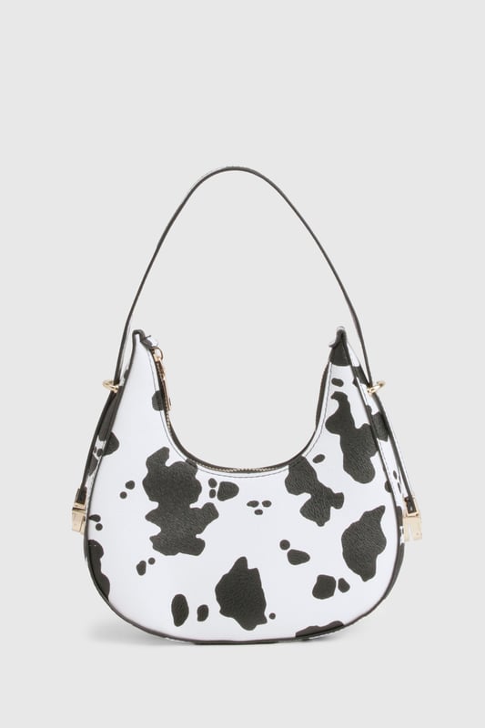 Cow Print Grab Bag Distinctive cow-print design for a bold statement accessory
Compact crescent shape with single shoulder strap
Gold-tone hardware accents for a luxe finish
Secure zip closure to keep essentials safe
Versatile size perfect for nights out
Make a fashion statement with this eye-catching cow-print bag that's sure to turn heads on your next night out. The trendy crescent silhouette sits comfortably under your arm whilst the adjustable shoulder strap offers practical versatility. Pair with a sleek black ensemble as shown for maximum impact, or use it to add a playful touch to any monochrome outfit. The compact yet practical size makes it ideal for carrying your essentials when hitting the club or meeting friends for drinks. The striking pattern works brilliantly against both casual and dressed-up looks - try styling with a little black dress and strappy heels for an evening at the bar, or with jeans and a crop top for a more relaxed approach to urban nightlife. This Boohoo bag delivers the perfect blend of fun and functionality for the fashion-forward partygoer.