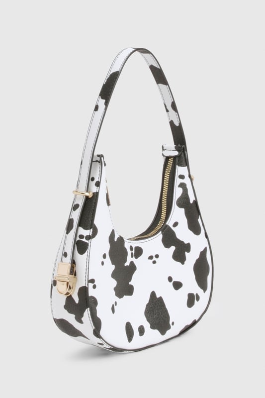 Cow Print Grab Bag Distinctive cow-print design for a bold statement accessory
Compact crescent shape with single shoulder strap
Gold-tone hardware accents for a luxe finish
Secure zip closure to keep essentials safe
Versatile size perfect for nights out
Make a fashion statement with this eye-catching cow-print bag that's sure to turn heads on your next night out. The trendy crescent silhouette sits comfortably under your arm whilst the adjustable shoulder strap offers practical versatility. Pair with a sleek black ensemble as shown for maximum impact, or use it to add a playful touch to any monochrome outfit. The compact yet practical size makes it ideal for carrying your essentials when hitting the club or meeting friends for drinks. The striking pattern works brilliantly against both casual and dressed-up looks - try styling with a little black dress and strappy heels for an evening at the bar, or with jeans and a crop top for a more relaxed approach to urban nightlife. This Boohoo bag delivers the perfect blend of fun and functionality for the fashion-forward partygoer.
