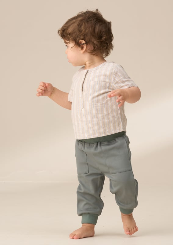 Sonny Stone Woven shirt bodice with trouser set Style and comfort come together in this smart woven shirt and trouser set. The textured neutral stripe shirt with a mandarin collar includes a clever mock bodysuit design for a fuss-free look. It’s perfectly paired with green woven joggers. complete with a soft ribbed waistband and cuffs for all-day comfort. Create a coordinated sibling look with the matching big brother shirt.
