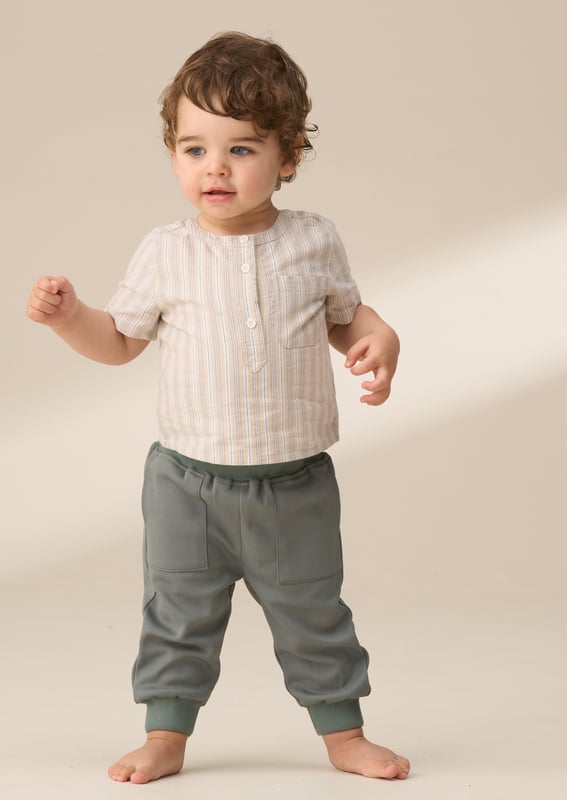 Sonny Stone Woven shirt bodice with trouser set Style and comfort come together in this smart woven shirt and trouser set. The textured neutral stripe shirt with a mandarin collar includes a clever mock bodysuit design for a fuss-free look. It’s perfectly paired with green woven joggers. complete with a soft ribbed waistband and cuffs for all-day comfort. Create a coordinated sibling look with the matching big brother shirt.