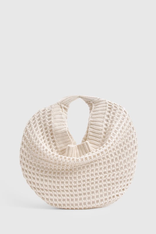 Distinctive crochet design with an open-weave pattern for a bohemian aesthetic
        Spacious interior perfect for carrying daily essentials
        Comfortable shoulder strap with reinforced edges for durability
        Rounded silhouette creates a relaxed, slouchy appearance
        Versatile design that complements both daytime and evening casual outfits
    
    This charming crochet shoulder bag brings a touch of artisanal flair to your everyday ensemble. The intricate open-weave pattern creates a delightful textural contrast against smooth fabrics, making it an eye-catching accessory for the fashion-forward woman. Style with a flowing midi dress and sandals for farmers' markets and seaside strolls, or pair with denim shorts and a simple tee for festival outings. The bag's generous capacity accommodates your phone, wallet, and beauty essentials without compromising on style. For cooler days, this bag works brilliantly with a casual jumper and straight-leg trousers. The neutral tone ensures it will coordinate seamlessly with your existing wardrobe, making it a versatile companion for casual gatherings and weekend brunches throughout the seasons.