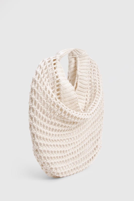 Distinctive crochet design with an open-weave pattern for a bohemian aesthetic
        Spacious interior perfect for carrying daily essentials
        Comfortable shoulder strap with reinforced edges for durability
        Rounded silhouette creates a relaxed, slouchy appearance
        Versatile design that complements both daytime and evening casual outfits
    
    This charming crochet shoulder bag brings a touch of artisanal flair to your everyday ensemble. The intricate open-weave pattern creates a delightful textural contrast against smooth fabrics, making it an eye-catching accessory for the fashion-forward woman. Style with a flowing midi dress and sandals for farmers' markets and seaside strolls, or pair with denim shorts and a simple tee for festival outings. The bag's generous capacity accommodates your phone, wallet, and beauty essentials without compromising on style. For cooler days, this bag works brilliantly with a casual jumper and straight-leg trousers. The neutral tone ensures it will coordinate seamlessly with your existing wardrobe, making it a versatile companion for casual gatherings and weekend brunches throughout the seasons.
