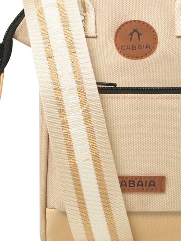 Diese kleine Umhängetasche vereint Funktionalität mit modernem Design. Das aufgenähte Frontlabel setzt einen stilvollen Akzent, während der praktische Reißverschluss das geräumige Hauptfach sicher verschließt. Zwei Innenfächer bieten Platz für wichtige Essentials, darunter Smartphones bis zu einer Höhe von 18 cm. Dank der großen Taschenöffnung ist der Inhalt leicht zugänglich. Der verstellbare, abnehmbare Schultergurt sowie zwei kurze Henkel mit verbindender Lasche ermöglichen vielseitige Tragemöglichkeiten. Gefertigt aus wasserabweisendem und besonders robustem Material, ist die Tasche ein idealer Begleiter für den Alltag. Ein besonderes Highlight ist die auswechselbare Vordertasche 'Nano Bag Fort De Sao Pedro', die mit Gurten und Druckknöpfen sicher befestigt wird. Diese Befestigung sorgt für zusätzlichen Diebstahlschutz. Bitte beachten: Die Schultergurte dieser Umhängetasche sind nicht mit den Gurten der Bauchtaschen kompatibel.
