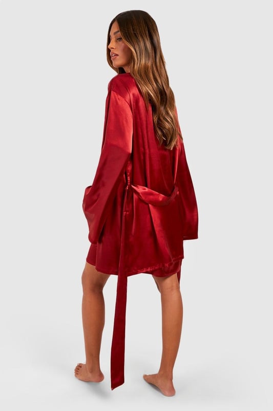 Flare Sleeve Tie Waist Satin Robe Luxurious satin finish that catches the light beautifully for a glamorous bedtime look
Dramatic flare sleeves that add a touch of elegance to your nightwear collection
Adjustable tie waist belt for a customised fit that flatters your silhouette
V-neckline design that creates a feminine and flattering frame
Mid-thigh length offering comfortable coverage whilst maintaining a stylish aesthetic
Transform your nightwear collection with this stunning satin robe from Boohoo. The sumptuous fabric glides against the skin for ultimate comfort, whilst the statement flare sleeves add a touch of drama to your evening routine. The adjustable tie waist allows you to create the perfect silhouette, whether worn loosely or cinched in. This versatile piece works brilliantly as part of a coordinated set with a matching slip or cami and shorts, or simply on its own for those warmer evenings. Perfect for lounging at home or packing for a weekend getaway, this robe combines practicality with style. The fluid drape of the fabric creates an effortlessly chic look that will make bedtime feel like a luxury experience every night.
