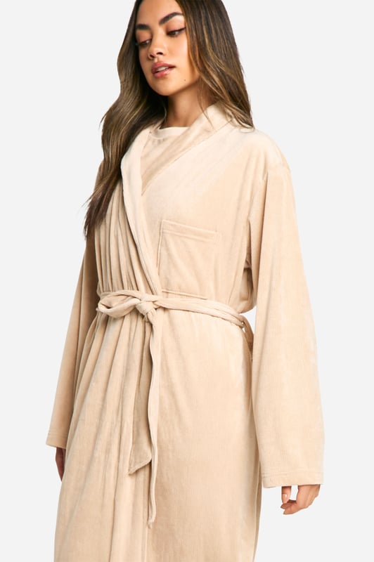 Luxuriously soft fleece fabric for ultimate comfort
        Full-length design for complete coverage
        Ribbed texture adds a stylish touch
        Belted waist for a customisable fit
        Versatile open front for easy wear
    
    Wrap yourself in cosy comfort with this ribbed fleece dressing gown from Boohoo. Perfect for lazy mornings and relaxing evenings, this full-length robe offers both warmth and style. The textured ribbed design adds a fashionable element to your nightwear collection, while the belted waist allows you to adjust the fit to your liking. Whether you're enjoying a cup of tea on the sofa or getting ready for bed, this versatile piece is an essential addition to your loungewear wardrobe. Pair it with your favourite pyjamas or wear it over a nightie for a complete look that's both practical and on-trend. Ideal for year-round use, this dressing gown is a must-have for the fashion-forward woman who values comfort without compromising on style.