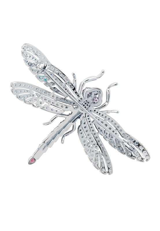 Dragonfly Brooch Silver Ruby Cz The Dragonfly Brooch is a masterfully crafted piece made from high-quality 925 sterling silver. This exquisite brooch captures the delicate beauty of a dragonfly, adorned with a dazzling array of ruby pink and white zirconia. The body of the dragonfly features alternating stripes of pink and white, along with pink eyes, creating a stunning visual contrast that is sure to catch the eye.The wings are intricately designed with a lace-like pattern, encrusted with sparkling white zirconia that shimmer with every movement. The tail of the dragonfly is elegantly finished with a larger ruby-coloured zirconia, making this brooch a true statement piece. Measuring 7.0cm in width, 5.0cm in length, and weighing a comfortable 12.7 grams, this brooch is perfect for adding a touch of glamour to any outfit.Dragonflies hold a special place in jewellery, symbolizing transformation, adaptability, and a deep connection to nature. They remind us to embrace change and live life to the fullest, making this brooch not just a beautiful accessory but a meaningful piece of art.Perfect for nature enthusiasts, lovers of fine craftsmanship, and anyone who appreciates unique and symbolic jewellery. Add the Dragonfly Brooch Silver Ruby Cz to your collection today and let its beauty and symbolism inspire you.