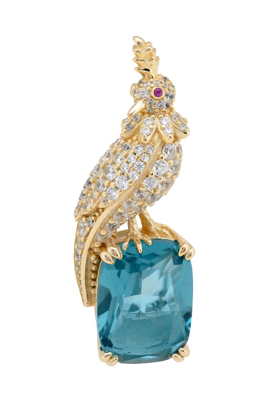 Crested Love Bird Brooch London Blue Topaz Gold Your brooch is a statement of elegance, inspired by the quiet majesty of nature. Designed in the image of a regal crested bird, this handcrafted piece is forged in 925 sterling silver and richly plated with 18ct gold for a luxurious finish that gleams with timeless beauty.Nestled beneath the zirconia-encrusted bird, a lab-created London blue topaz—cut to a refined rectangular silhouette—adds a deep, oceanic sparkle that captivates in every light. At 3.8 cm long, 1.4cm wide and just 7.0 grams in weight, your brooch wears with comfortable grace on any lapel, scarf, or dress.Whether you're accenting a formal look or adding a touch of opulence to your everyday style, your brooch offers a wearable blend of art, craftsmanship, and storytelling. This is more than an accessory—it’s a piece that speaks.