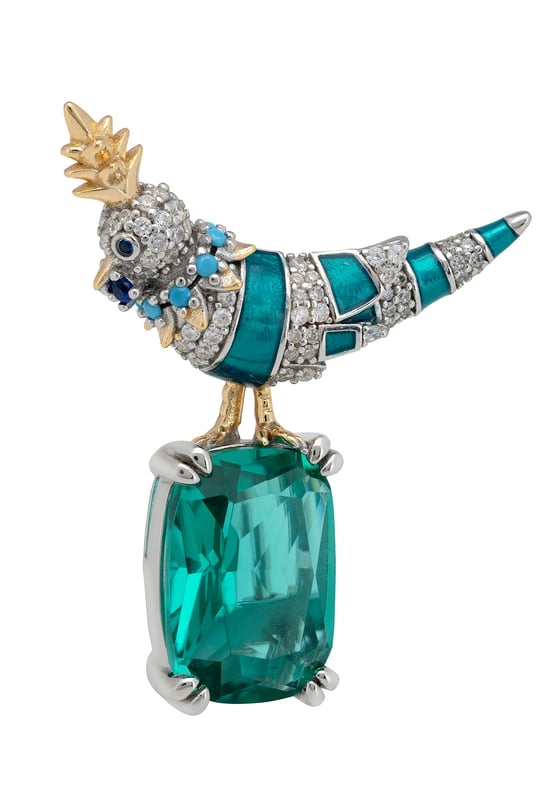 Make a graceful impression with a brooch that captures the essence of nature and the craftsmanship of fine jewellery. Inspired by the striking beauty of a crested love bird and designed for those who appreciate intricate detail and timeless elegance, it blends organic charm with elevated materials for a result that is both eye-catching and tasteful.Handcrafted from 925 sterling silver, the bird’s body is brought to life through a vivid green enamel finish, enhanced by a trail of sparkling clear zircons that catch the light with every turn. Its crest and legs are accented in lustrous gold plating, adding warmth and contrast to the design. A delicate collar of turquoise zircons encircles the neck, drawing the eye with a subtle pop of colour. Perched confidently atop a rectangular-cut lab-grown emerald, the love bird forms a stunning focal point.With dimensions of 3.0 cm in width, 3.6 cm in depth, and a weight of 7.5 grams, this brooch is perfectly sized to make a statement without overwhelming. It’s a celebration of beauty, craftsmanship, and charm in one wearable work of art.