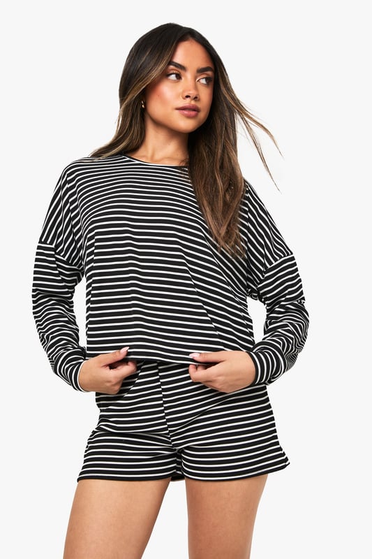 Loungewear Stripe Long Sleeve Top & Shorts Pyjama Set Relaxed fit long-sleeved jersey top with classic horizontal stripe pattern
Dropped shoulder design for effortless comfort and contemporary silhouette
Matching shorts with comfortable elastic waistband for ease of movement
Soft knitted jersey fabric that's gentle against the skin
Versatile two-piece set that can be worn together or styled separately
Embrace laid-back luxury with this striped jersey co-ord set from Boohoo. The oversized long-sleeved top features a relaxed fit with dropped shoulders that creates an effortlessly chic silhouette, whilst the matching shorts offer the perfect balance of comfort and style. Perfect for those cosy nights in when you still want to look put-together, this set is ideal for lounging, weekend brunches at home, or casual film nights with friends. Style with fluffy socks and your favourite oversized cardigan when temperatures drop, or wear the pieces separately to maximise your wardrobe options. The timeless stripe pattern ensures this set will remain a staple in your loungewear collection for seasons to come, whilst the soft knitted fabric provides that much-needed comfort for your downtime moments.