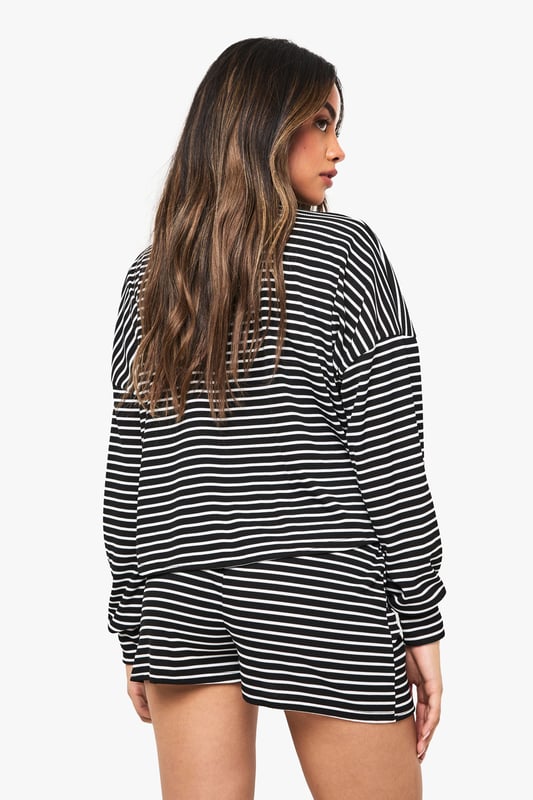 Loungewear Stripe Long Sleeve Top & Shorts Pyjama Set Relaxed fit long-sleeved jersey top with classic horizontal stripe pattern
Dropped shoulder design for effortless comfort and contemporary silhouette
Matching shorts with comfortable elastic waistband for ease of movement
Soft knitted jersey fabric that's gentle against the skin
Versatile two-piece set that can be worn together or styled separately
Embrace laid-back luxury with this striped jersey co-ord set from Boohoo. The oversized long-sleeved top features a relaxed fit with dropped shoulders that creates an effortlessly chic silhouette, whilst the matching shorts offer the perfect balance of comfort and style. Perfect for those cosy nights in when you still want to look put-together, this set is ideal for lounging, weekend brunches at home, or casual film nights with friends. Style with fluffy socks and your favourite oversized cardigan when temperatures drop, or wear the pieces separately to maximise your wardrobe options. The timeless stripe pattern ensures this set will remain a staple in your loungewear collection for seasons to come, whilst the soft knitted fabric provides that much-needed comfort for your downtime moments.