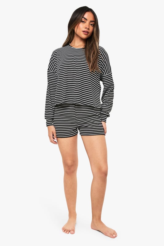 Loungewear Stripe Long Sleeve Top & Shorts Pyjama Set Relaxed fit long-sleeved jersey top with classic horizontal stripe pattern
Dropped shoulder design for effortless comfort and contemporary silhouette
Matching shorts with comfortable elastic waistband for ease of movement
Soft knitted jersey fabric that's gentle against the skin
Versatile two-piece set that can be worn together or styled separately
Embrace laid-back luxury with this striped jersey co-ord set from Boohoo. The oversized long-sleeved top features a relaxed fit with dropped shoulders that creates an effortlessly chic silhouette, whilst the matching shorts offer the perfect balance of comfort and style. Perfect for those cosy nights in when you still want to look put-together, this set is ideal for lounging, weekend brunches at home, or casual film nights with friends. Style with fluffy socks and your favourite oversized cardigan when temperatures drop, or wear the pieces separately to maximise your wardrobe options. The timeless stripe pattern ensures this set will remain a staple in your loungewear collection for seasons to come, whilst the soft knitted fabric provides that much-needed comfort for your downtime moments.