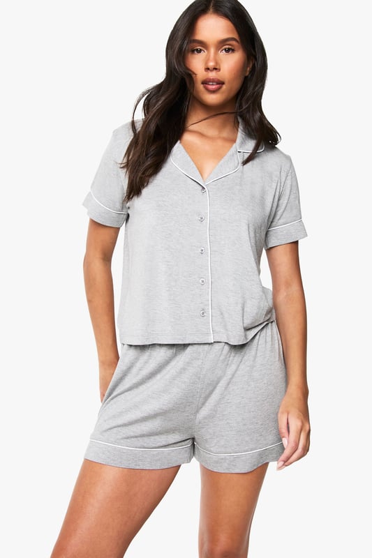 Premium Modal Piping Detail Short Sleeve Shirt & Shorts Pyjama Set Classic button-through shirt with notched collar for a sophisticated nightwear look
Short sleeves with neat cuffed detailing for a polished finish
Relaxed fit shorts with comfortable elasticated waistband
Soft jersey fabric that drapes beautifully for ultimate comfort
Coordinated two-piece set that can be worn together or separately
Embrace bedtime bliss with this chic short-sleeved shirt and shorts set from Boohoo. The traditional shirt styling brings a touch of refinement to your nightwear collection, whilst the relaxed fit ensures maximum comfort for a restful night's sleep. Perfect for warm summer evenings or cosy nights in, this versatile set works brilliantly for lounging about on lazy weekend mornings with a cup of tea and your favourite book. The matching set offers effortless style without compromising on comfort, making it ideal for those impromptu doorstep deliveries or quick dashes to the kitchen. For cooler nights, simply pair with fluffy socks or layer with a lightweight dressing gown. This nightwear essential reflects Boohoo's commitment to creating fashion that's both accessible and on-trend, ensuring you look stylish even when you're winding down.