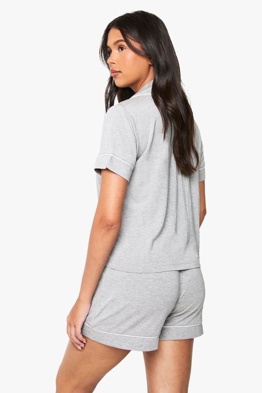 Premium Modal Piping Detail Short Sleeve Shirt & Shorts Pyjama Set Classic button-through shirt with notched collar for a sophisticated nightwear look
Short sleeves with neat cuffed detailing for a polished finish
Relaxed fit shorts with comfortable elasticated waistband
Soft jersey fabric that drapes beautifully for ultimate comfort
Coordinated two-piece set that can be worn together or separately
Embrace bedtime bliss with this chic short-sleeved shirt and shorts set from Boohoo. The traditional shirt styling brings a touch of refinement to your nightwear collection, whilst the relaxed fit ensures maximum comfort for a restful night's sleep. Perfect for warm summer evenings or cosy nights in, this versatile set works brilliantly for lounging about on lazy weekend mornings with a cup of tea and your favourite book. The matching set offers effortless style without compromising on comfort, making it ideal for those impromptu doorstep deliveries or quick dashes to the kitchen. For cooler nights, simply pair with fluffy socks or layer with a lightweight dressing gown. This nightwear essential reflects Boohoo's commitment to creating fashion that's both accessible and on-trend, ensuring you look stylish even when you're winding down.