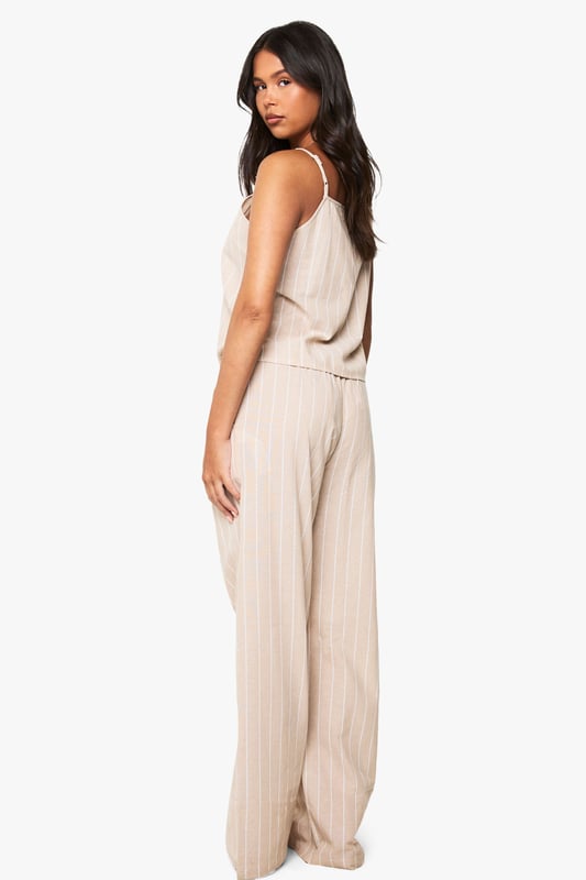 Soft cotton pyjama set featuring classic pinstripe pattern throughout
        Relaxed cami top with delicate adjustable straps and flattering V-neckline
        Wide-leg trousers with comfortable elasticated waistband for ease of movement
        Two-piece design allows for mix-and-match styling options
        Lightweight fabric ensures breathability for a comfortable night's sleep
    
    Drift into dreamland in style with this chic cotton pinstripe pyjama set from Boohoo. The relaxed silhouette combines comfort with contemporary design, making bedtime a fashionable affair. The cami top features a flattering V-neckline that creates an elegant look, whilst the wide-leg trousers offer unrestricted movement for a peaceful night's rest. Perfect for lounging at home on lazy weekend mornings or for packing on your next weekend getaway. For cooler evenings, simply layer with a soft dressing gown or oversized cardigan. This versatile set transitions effortlessly from night to morning, allowing you to enjoy your first cup of tea in comfort without compromising on style. The timeless pinstripe pattern adds a touch of sophistication to your nightwear collection.