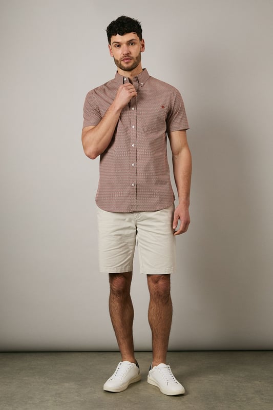 Orange Geo Print Short Sleeve Shirt Distinctive geo print pattern creates visual interest across the entire shirt
Classic button-down collar for a smart-casual finish
Short sleeves with neat hems perfect for warmer weather
Signature Maine embroidered logo detail on chest
Centre back pleat for enhanced comfort and movement
This Maine geo print shirt combines contemporary pattern with timeless design for versatile summer styling. The pure cotton fabric ensures breathability and comfort throughout the day, whilst the structured button-down collar maintains a refined appearance even when worn casually. Style as seen with neutral shorts and white trainers for relaxed weekend brunches or garden gatherings. For evening socials, pair with chinos and loafers for an effortlessly sophisticated look. The subtle geometric pattern works brilliantly with solid-coloured bottoms, allowing the shirt to be the focal point of your ensemble. Perfect for holidays, casual Fridays at the office, or simply elevating your everyday wardrobe with a touch of considered pattern.