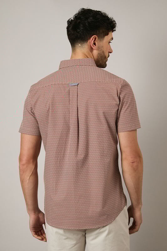 Orange Geo Print Short Sleeve Shirt Distinctive geo print pattern creates visual interest across the entire shirt
Classic button-down collar for a smart-casual finish
Short sleeves with neat hems perfect for warmer weather
Signature Maine embroidered logo detail on chest
Centre back pleat for enhanced comfort and movement
This Maine geo print shirt combines contemporary pattern with timeless design for versatile summer styling. The pure cotton fabric ensures breathability and comfort throughout the day, whilst the structured button-down collar maintains a refined appearance even when worn casually. Style as seen with neutral shorts and white trainers for relaxed weekend brunches or garden gatherings. For evening socials, pair with chinos and loafers for an effortlessly sophisticated look. The subtle geometric pattern works brilliantly with solid-coloured bottoms, allowing the shirt to be the focal point of your ensemble. Perfect for holidays, casual Fridays at the office, or simply elevating your everyday wardrobe with a touch of considered pattern.