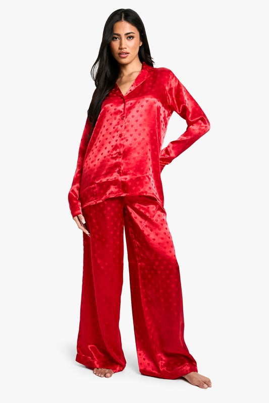 Satin Heart Jacquard Shirt & Trouser Pyjama Set Luxurious satin fabric with charming heart-print jacquard pattern
Relaxed fit shirt with classic collar and button-down front
Long sleeves for cosy comfort
Wide-leg trousers with elasticated waistband for ease of movement
Versatile two-piece set perfect for lounging or sleeping
Indulge in the ultimate night-time luxury with this stunning satin jacquard shirt and trouser set. The alluring heart-print pattern adds a touch of romance to your bedtime routine, while the soft, smooth fabric gently caresses your skin for a truly comfortable sleep. The relaxed fit of both pieces ensures unrestricted movement, whether you're curling up with a good book or catching some well-deserved shut-eye. Style this set with cosy slippers and a plush dressing gown for those chilly evenings, or wear it on its own during warmer nights. Perfect for lazy weekend mornings or impromptu video calls with friends, this versatile pyjama set effortlessly combines style and comfort. Make bedtime your most fashionable hour with this must-have addition to your nightwear collection.