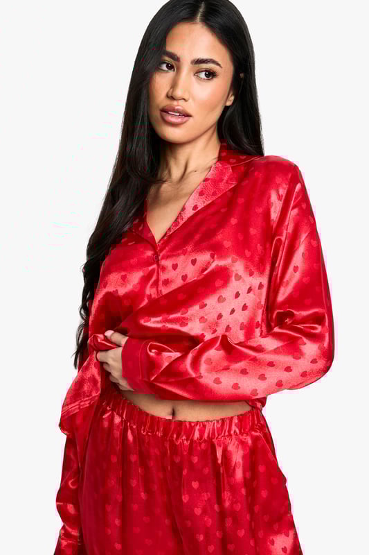 Satin Heart Jacquard Shirt & Trouser Pyjama Set Luxurious satin fabric with charming heart-print jacquard pattern
Relaxed fit shirt with classic collar and button-down front
Long sleeves for cosy comfort
Wide-leg trousers with elasticated waistband for ease of movement
Versatile two-piece set perfect for lounging or sleeping
Indulge in the ultimate night-time luxury with this stunning satin jacquard shirt and trouser set. The alluring heart-print pattern adds a touch of romance to your bedtime routine, while the soft, smooth fabric gently caresses your skin for a truly comfortable sleep. The relaxed fit of both pieces ensures unrestricted movement, whether you're curling up with a good book or catching some well-deserved shut-eye. Style this set with cosy slippers and a plush dressing gown for those chilly evenings, or wear it on its own during warmer nights. Perfect for lazy weekend mornings or impromptu video calls with friends, this versatile pyjama set effortlessly combines style and comfort. Make bedtime your most fashionable hour with this must-have addition to your nightwear collection.