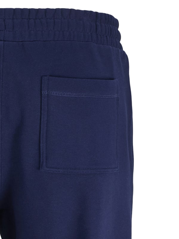 In dieser Jogginghose fühlst du dich den ganzen Tag rundum wohl. Die normale Passform mit geradem Bein bietet dir viel Bewegungsfreiheit. Ein elastischer Bund mit Tunnelzug sorgt für perfekten Sitz – ganz ohne Zwicken. Die Rippbündchen an den Beinabschlüssen halten alles bequem an Ort und Stelle. Das gestickte Logo auf dem Bein verleiht der Hose einen sportlichen Look. In der Gesäßtasche kannst du kleine Dinge sicher verstauen. Der weiche Stoff trägt sich angenehm und macht jede Bewegung mit. Ob zu Hause, auf dem Spielplatz oder beim Sport – diese Hose passt immer. Du kombinierst sie ganz easy mit deinen Lieblingsshirts oder Hoodies. Einfach reinschlüpfen und los geht's!