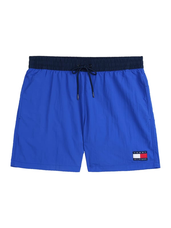 Tommy Hilfiger Schwimmshorts Diese Herren-Badeshorts im Slim Fit überzeugen mit sportlicher Eleganz und passgenauem Sitz. Der oberschenkellange Schnitt betont die Figur und bietet dennoch volle Bewegungsfreiheit. Ein farblich abgesetzter Bund mit Tunnelzug setzt einen frischen Akzent und sorgt für sicheren Halt. Seitliche Eingrifftaschen und eine Gesäßtasche bieten praktische Verstaumöglichkeiten. Der elastische Bund passt sich flexibel an – ideal für aktive Tage am Wasser. Der leichte Stoff trocknet schnell und trägt sich auch nach dem Schwimmen angenehm. Ein dezenter Label-Aufnäher am Bein rundet das Design markant ab. Diese Shorts machen am Strand ebenso eine gute Figur wie auf der Promenade. Schmal geschnitten, aber maximal bequem. Für Männer, die auf Stil auch beim Baden nicht verzichten möchten.