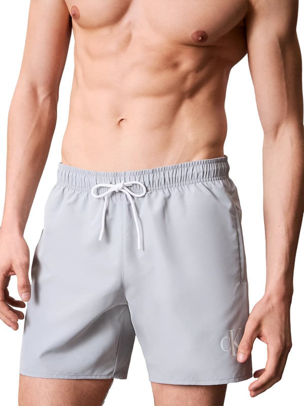 Diese mittellangen Herren-Badeshorts sind der perfekte Begleiter für stilvolle Sommertage. Der elastische Bund mit Tunnelzug garantiert nicht nur optimalen Halt, sondern lässt sich individuell anpassen. Seitliche Eingrifftaschen bieten Platz für Sonnenbrille, Schlüssel oder Muschelfunde. Eine zusätzliche Gesäßtasche sorgt für praktischen Stauraum mit lässigem Touch. Das atmungsaktive Mesh-Futter verleiht ein angenehm leichtes Tragegefühl – selbst bei hohen Temperaturen. Ein dezenter Monogramm-Print am Saum setzt ein modisches Statement ohne aufzutragen. Die Shorts überzeugen mit einem sportlich-eleganten Look, der sowohl am Strand als auch an der Strandbar funktioniert. Schnell übergezogen, sofort wohlgefühlt. Komfort und Stil gehen hier Hand in Hand. Für Männer, die es entspannt mögen, aber dennoch Wert auf Details legen.