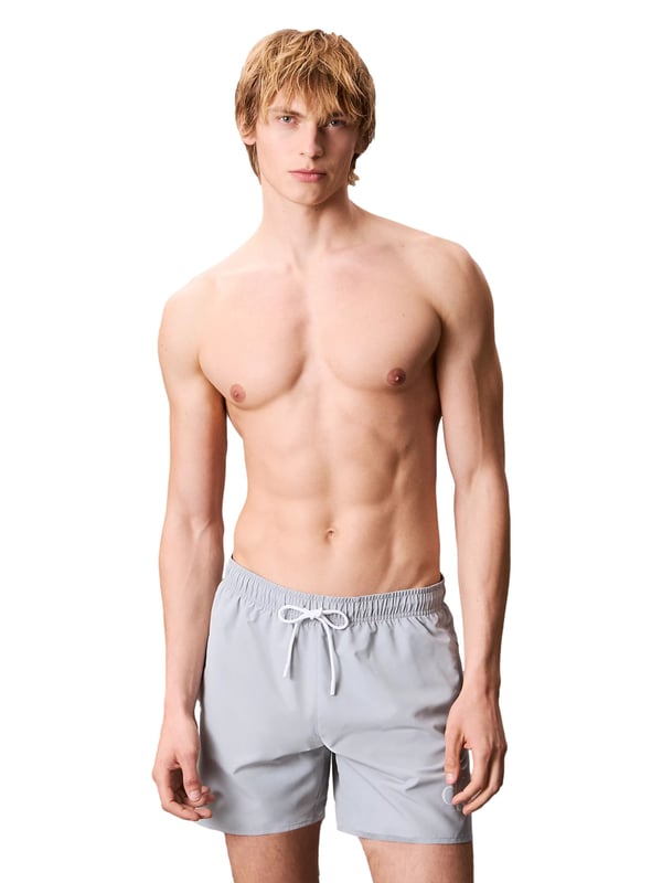 Diese mittellangen Herren-Badeshorts sind der perfekte Begleiter für stilvolle Sommertage. Der elastische Bund mit Tunnelzug garantiert nicht nur optimalen Halt, sondern lässt sich individuell anpassen. Seitliche Eingrifftaschen bieten Platz für Sonnenbrille, Schlüssel oder Muschelfunde. Eine zusätzliche Gesäßtasche sorgt für praktischen Stauraum mit lässigem Touch. Das atmungsaktive Mesh-Futter verleiht ein angenehm leichtes Tragegefühl – selbst bei hohen Temperaturen. Ein dezenter Monogramm-Print am Saum setzt ein modisches Statement ohne aufzutragen. Die Shorts überzeugen mit einem sportlich-eleganten Look, der sowohl am Strand als auch an der Strandbar funktioniert. Schnell übergezogen, sofort wohlgefühlt. Komfort und Stil gehen hier Hand in Hand. Für Männer, die es entspannt mögen, aber dennoch Wert auf Details legen.