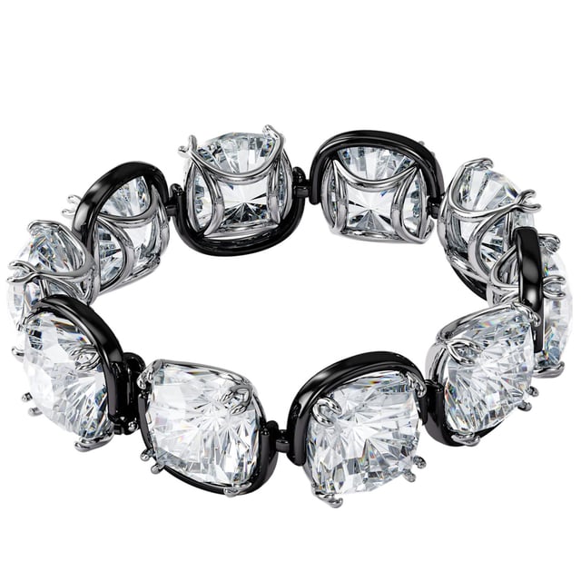 Combining mystery and whimsy, this cuff bracelet creates the illusion of floating stones. It is expertly crafted from a row of oversized cushion-cut clear crystals in an elegant claw setting. Pair it with sleek black evening gloves or a simple long-sleeved T-shirt to elevate your daytime look. Part of the Harmonia family, this bracelet was designed by creative director Giovanna Engelbert for Collection I. How to fasten and open: Place the bar with the rounded end at the widest point of the opposite gap and slide it into the narrower gap. Once in place, pull down the safety clasp at the top to secure the closure. To open, lift the safety clasp and slide the bar into the wider gap to release.\n Measures: Length (minimum - maximum): 16.5 - 22.7 cm\n Width: 1.7 cm\n Composition: Material: Crystals, Various metallic finishes\n Care:\nAvoid contact with creams, perfumes and detergents that may damage the product. To maintain its shine, we recommend cleaning it only with a soft cloth.