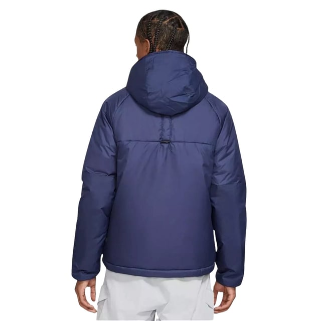 Stay warm and dry with the Nike Dark Blue Padded Jacket, crafted from 100% polyester with Therma-FIT technology to retain heat efficiently. This water-repellent jacket features a full zip fastening for easy wear, two front pockets secured with buttons, and a zippered left breast pocket for secure storage. The attached hood offers extra protection against the elements, while the iconic Nike badge on the left breast adds a stylish touch. Perfect for outdoor activities or casual wear, this jacket combines functionality and comfort in a sleek design
