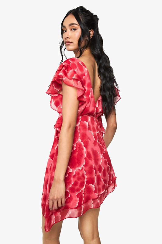 Flirty plunge neckline creates a striking focal point
        Delicate chiffon fabric with all-over floral pattern for a feminine touch
        Romantic ruffle detailing on the short sleeves adds movement and dimension
        Asymmetric hemline with lace trim creates visual interest
        Mini length silhouette perfect for showcasing your legs
    
    Make a statement at your next casual gathering in this enchanting chiffon mini dress from Boohoo. The eye-catching plunge neckline and fluttery ruffle sleeves create a playful yet sophisticated silhouette that's perfect for day-to-night transitions. The asymmetric hemline with delicate lace trim adds a contemporary twist to this feminine piece. Style with strappy sandals and minimal gold jewellery as seen on our model for family gatherings or weekend brunches. For cooler evenings, layer with a cropped denim jacket and ankle boots. This versatile dress works beautifully for garden parties, casual dates, or styled with trainers for a more relaxed daytime look. The lightweight chiffon fabric ensures comfort while maintaining that effortlessly chic aesthetic that's quintessentially Boohoo.